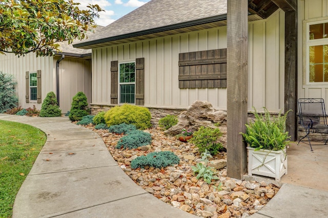 1721 Jackson Spring Rd, Ozark, MO 65721 - view of exterior entry featuring roof with shingles, board and batten siding, and stone siding