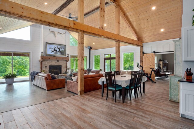 1721 Jackson Spring Rd, Ozark, MO 65721 - living room featuring high vaulted ceiling, a barn door, a wooden ceiling with exposed beams, a stone fireplace, and light wood finished floors