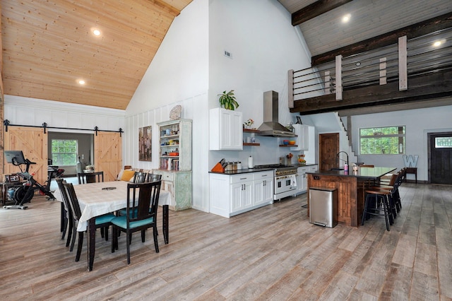 1721 Jackson Spring Rd, Ozark, MO 65721 - kitchen featuring island range hood, range with two ovens, high vaulted ceiling, a barn door, and dark countertops
