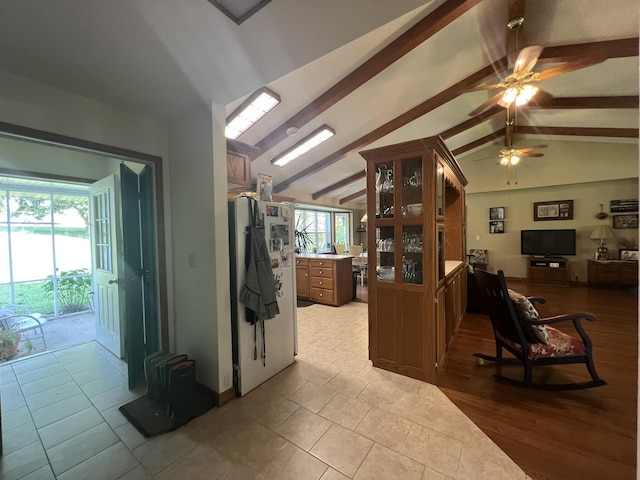 1014 Sassafras St, Willow Springs, MO 65793 - kitchen featuring a ceiling fan, glass insert cabinets, brown cabinetry, light tile patterned flooring, and open floor plan