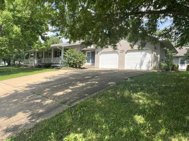 1014 Sassafras St, Willow Springs, MO 65793 - single story home featuring asphalt driveway, covered porch, a garage, and a front yard