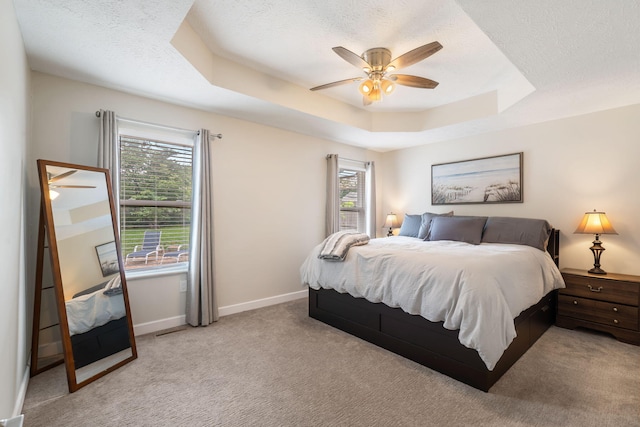 3115 E Lark St, Springfield, MO 65804 - carpeted bedroom featuring multiple windows, a raised ceiling, a textured ceiling, and a ceiling fan