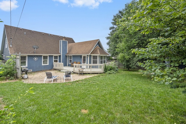 3115 E Lark St, Springfield, MO 65804 - rear view of property featuring a patio, a yard, a sunroom, a shingled roof, and a wooden deck