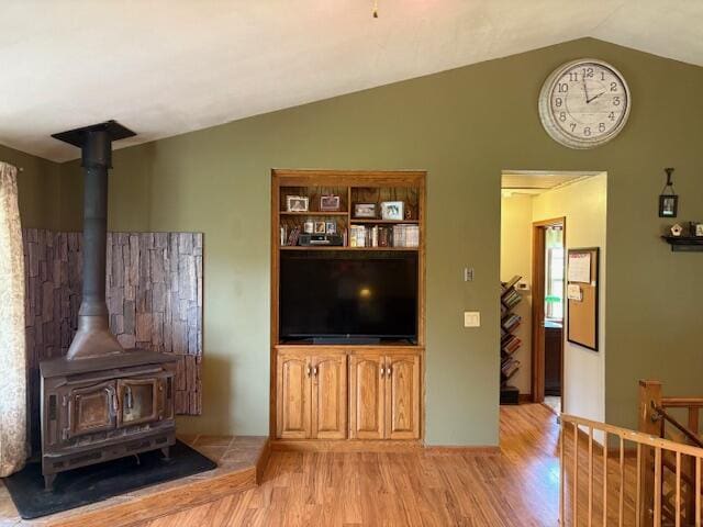 21572 Lawrence Unit 1240, Aurora, MO 65605 - living room featuring light wood-type flooring, vaulted ceiling, and a wood stove