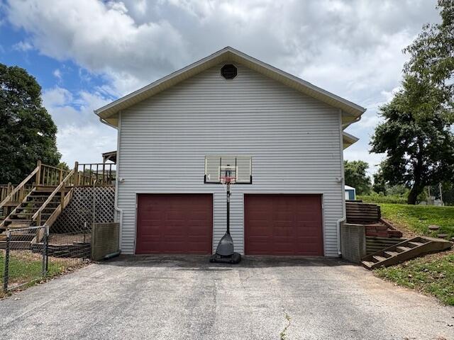 21572 Lawrence Unit 1240, Aurora, MO 65605 - view of home's exterior with stairway, driveway, an attached garage, and a deck