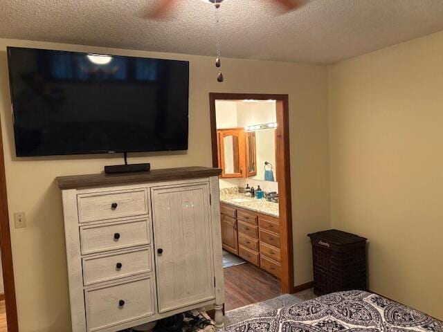 21572 Lawrence Unit 1240, Aurora, MO 65605 - bedroom featuring a textured ceiling, ensuite bath, and wood finished floors