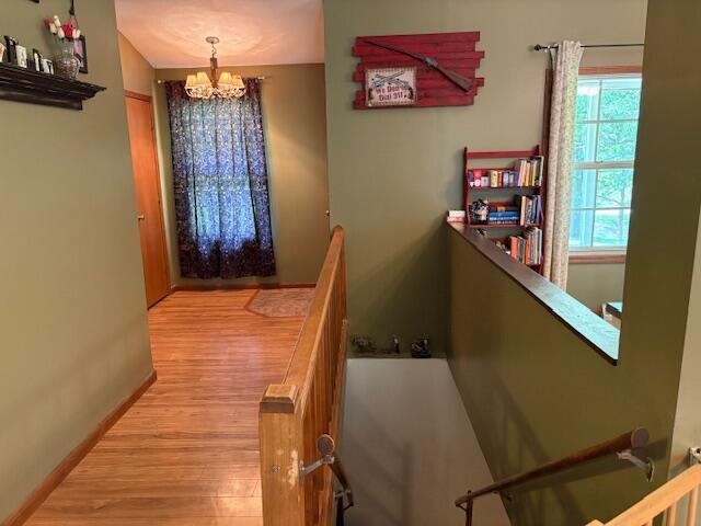 21572 Lawrence Unit 1240, Aurora, MO 65605 - hallway with a chandelier, an upstairs landing, and wood finished floors