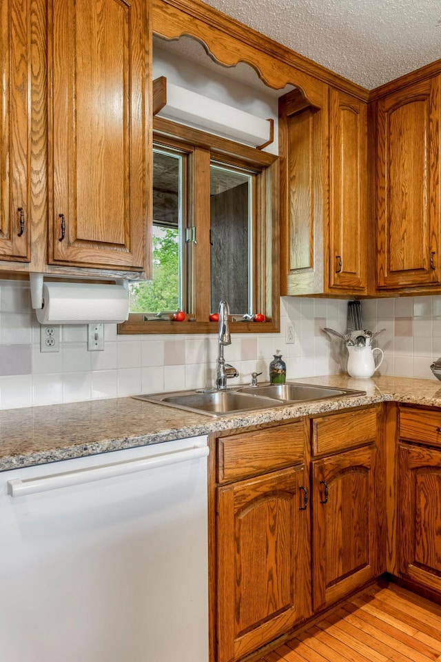 4949 S 196th Rd, Halfway, MO 65663 - kitchen featuring decorative backsplash, brown cabinets, light wood-type flooring, light stone countertops, and a textured ceiling