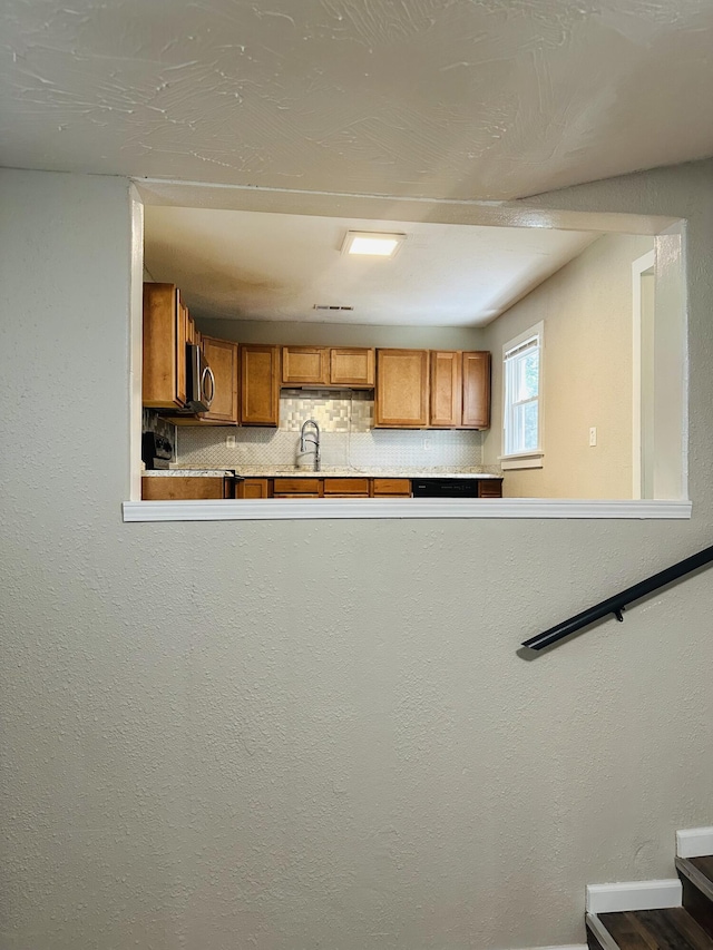 652 W Hovey St, Springfield, MO 65802 - kitchen with brown cabinets, backsplash, and stainless steel microwave