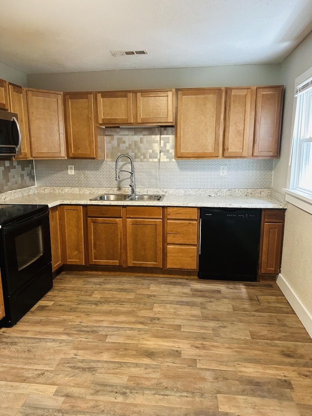 652 W Hovey St, Springfield, MO 65802 - kitchen with black appliances, backsplash, light countertops, and light wood-style floors