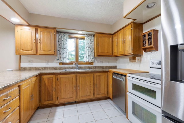 3047 S Ferguson Ave, Springfield, MO 65807 - kitchen with stainless steel appliances, brown cabinets, backsplash, light tile patterned flooring, and a textured ceiling