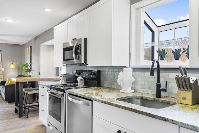 kitchen featuring appliances with stainless steel finishes, white cabinetry, tasteful backsplash, and recessed lighting