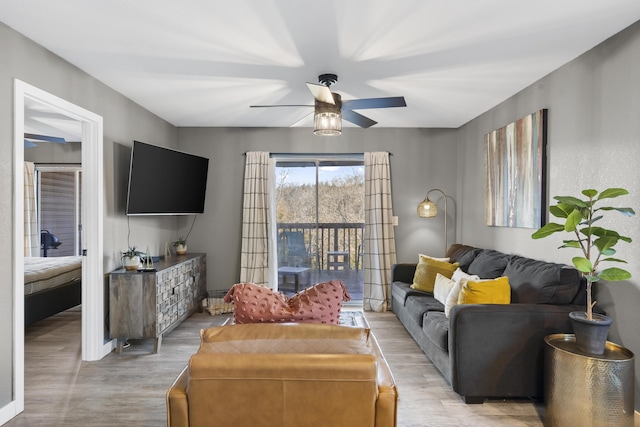 living room featuring light wood-type flooring and ceiling fan