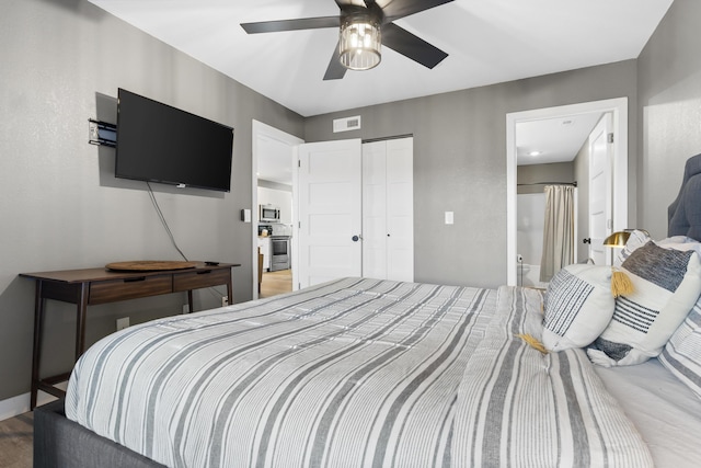 bedroom with a closet, a ceiling fan, and ensuite bath