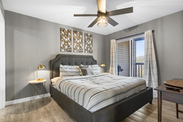 bedroom featuring access to exterior, wood finished floors, and a ceiling fan