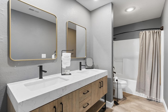 bathroom featuring wood finished floors, double vanity, and shower / tub combo with curtain