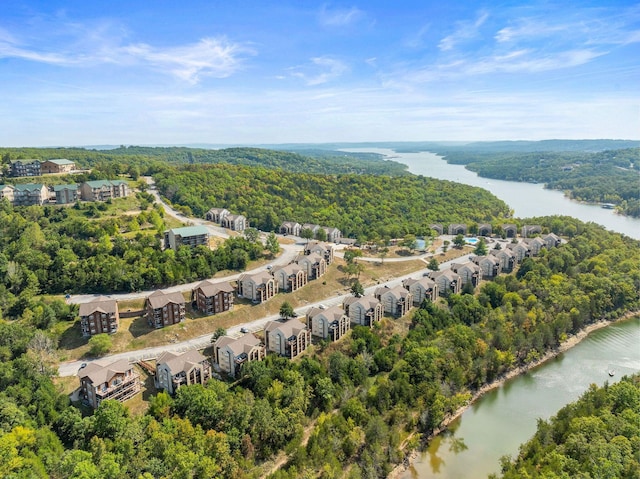 drone / aerial view of a heavily wooded area and a large body of water
