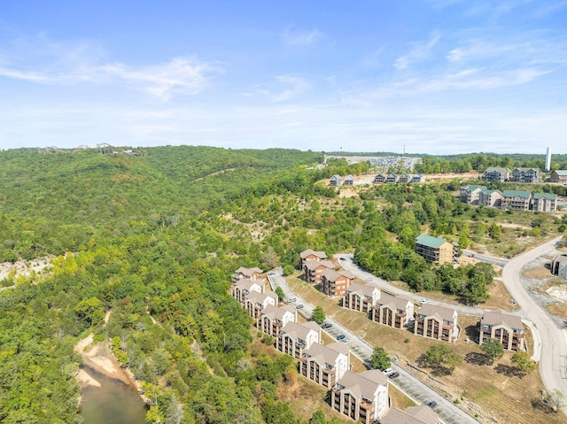 aerial view of property and surrounding area featuring a forest