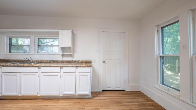 220 S 3rd St, Thayer, MO 65791 - kitchen featuring healthy amount of natural light, light wood-style flooring, and white cabinets