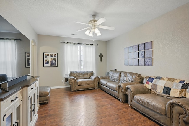 1925 Sylvan Ave, Neosho, MO 64850 - living area with dark wood-style floors, ceiling fan, and a textured ceiling