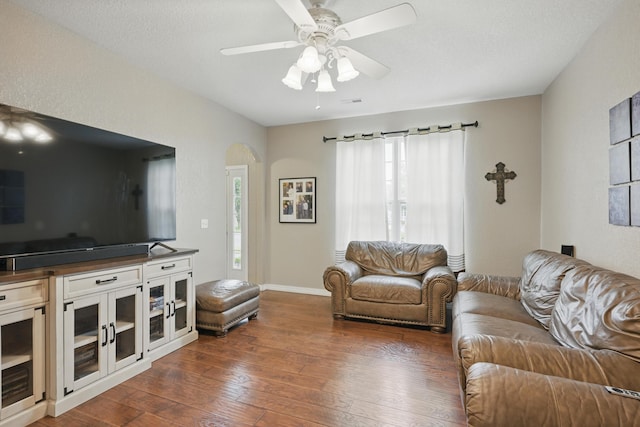 1925 Sylvan Ave, Neosho, MO 64850 - living area featuring arched walkways, dark wood finished floors, and a ceiling fan