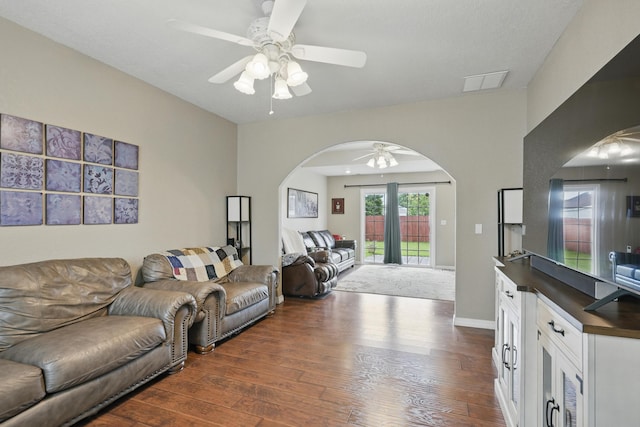 1925 Sylvan Ave, Neosho, MO 64850 - living room featuring arched walkways, ceiling fan, and dark wood-type flooring