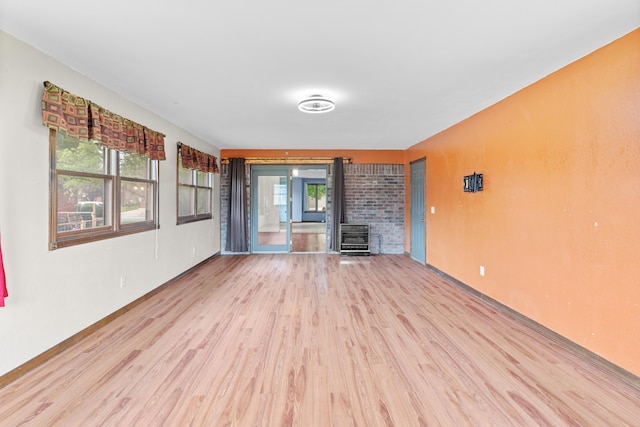 1007 W Bryce Ln, Nixa, MO 65714 - unfurnished living room with light wood-style floors, healthy amount of natural light, heating unit, and a wood stove