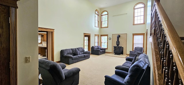 3889 E State Highway Kk, Fair Grove, MO 65648 - carpeted living area featuring a towering ceiling, a wood stove, and stairs