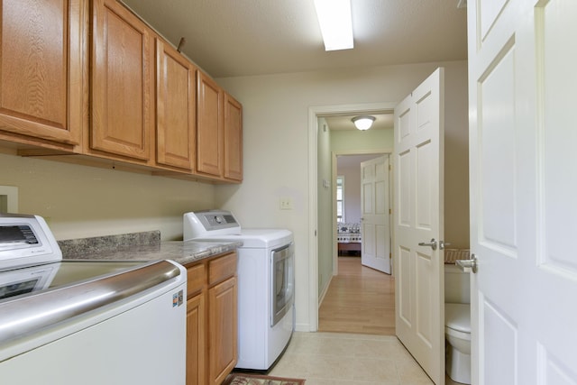 164 Sweet Home Trl, Theodosia, MO 65761 - washroom featuring washing machine and dryer, cabinet space, and light tile patterned floors