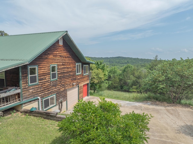 164 Sweet Home Trl, Theodosia, MO 65761 - view of side of home featuring concrete driveway, a metal roof, an attached garage, and a forest view