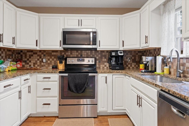 759 S Troy Ave, Springfield, MO 65802 - kitchen featuring appliances with stainless steel finishes, white cabinets, backsplash, and stone countertops