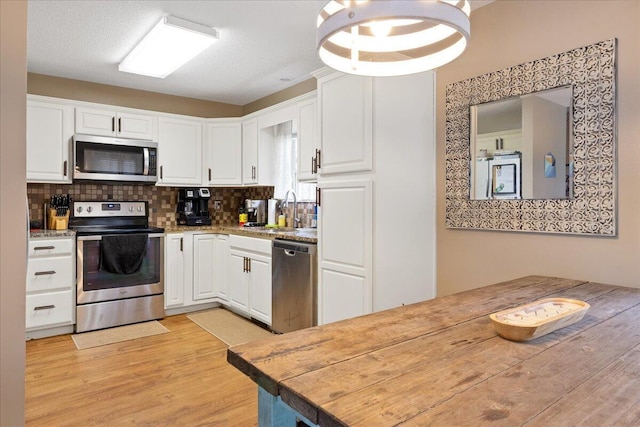 759 S Troy Ave, Springfield, MO 65802 - kitchen with stainless steel appliances, white cabinets, tasteful backsplash, and light wood-style flooring