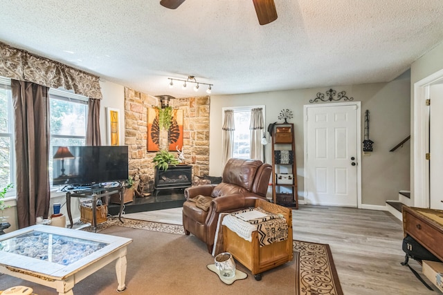 426 Lakewood Rd, Branson, MO 65616 - living room featuring a textured ceiling, stairway, ceiling fan, light wood-type flooring, and a wood stove