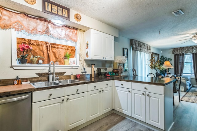 426 Lakewood Rd, Branson, MO 65616 - kitchen featuring dishwasher, a peninsula, a textured ceiling, dark countertops, and wood finished floors