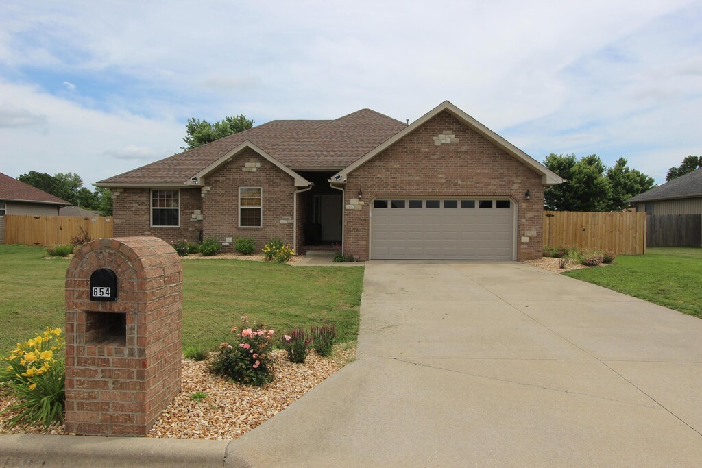 654 Boardwalk, Seymour, MO 65746 - view of front of property featuring an attached garage, brick siding, concrete driveway, and a shingled roof