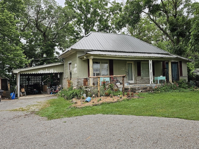 502 S Gilman Ave, Wheaton, MO 64874 - view of front of house featuring a porch, driveway, an attached carport, stone siding, and a front yard