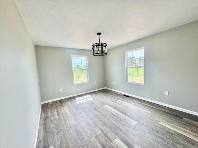 2605 Country Dr, Mountain Grove, MO 65711 - spare room featuring a chandelier, plenty of natural light, and wood finished floors