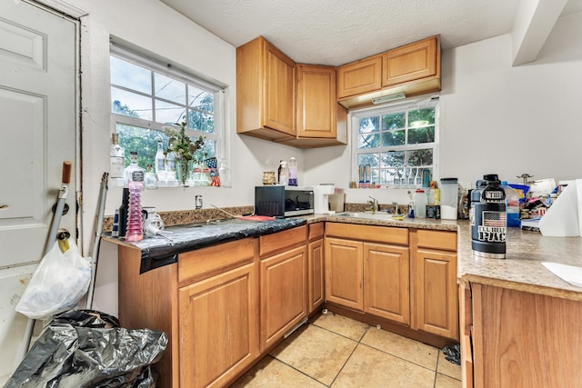 1673 E Chestnut St, Springfield, MO 65802 - kitchen featuring stainless steel microwave, light tile patterned flooring, plenty of natural light, and brown cabinets