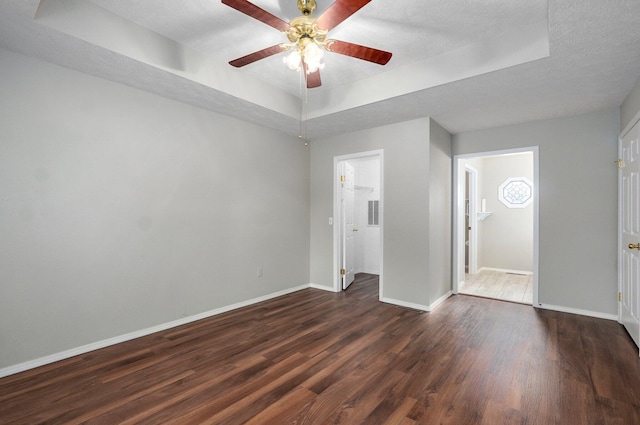 2606 S Overbrook Ave, Springfield, MO 65807 - unfurnished bedroom featuring a raised ceiling, dark wood-style flooring, and a ceiling fan