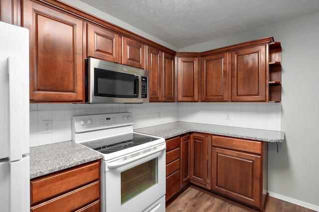 2606 S Overbrook Ave, Springfield, MO 65807 - kitchen featuring white appliances, wood finished floors, decorative backsplash, light countertops, and a textured ceiling