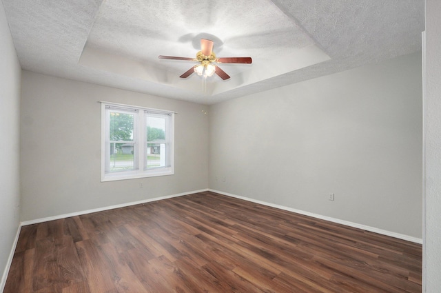 2606 S Overbrook Ave, Springfield, MO 65807 - unfurnished room featuring a raised ceiling, a textured ceiling, dark wood finished floors, and a ceiling fan