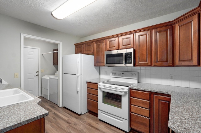 2606 S Overbrook Ave, Springfield, MO 65807 - kitchen with white appliances, independent washer and dryer, wood finished floors, decorative backsplash, and a textured ceiling