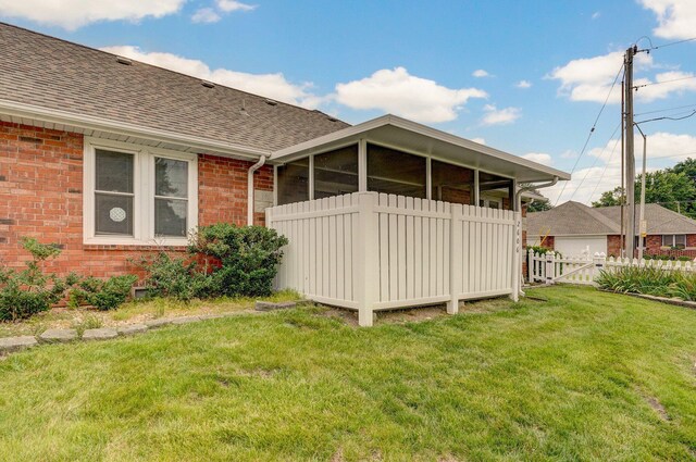2606 S Overbrook Ave, Springfield, MO 65807 - rear view of house featuring a shingled roof, brick siding, and a sunroom
