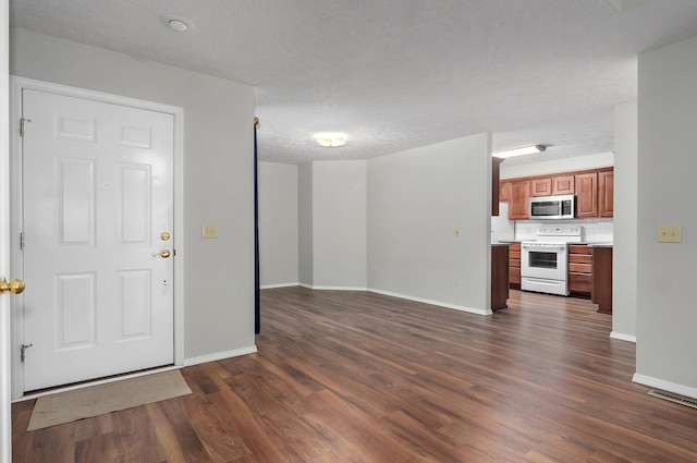 2606 S Overbrook Ave, Springfield, MO 65807 - unfurnished living room with dark wood-type flooring and a textured ceiling