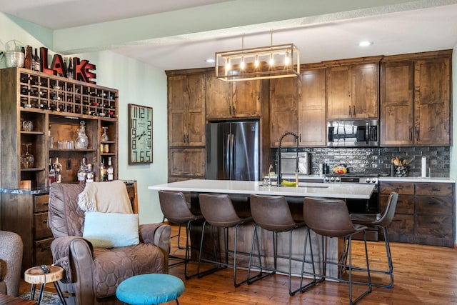 6089 State Highway Dd Unit 103, Branson West, MO 65737 - kitchen with appliances with stainless steel finishes, tasteful backsplash, light countertops, a breakfast bar area, and recessed lighting