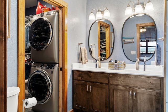 6089 State Highway Dd Unit 103, Branson West, MO 65737 - bathroom featuring stacked washing machine and dryer, a textured wall, double vanity, and a spacious closet