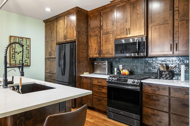 6089 State Highway Dd Unit 103, Branson West, MO 65737 - kitchen with stainless steel appliances, decorative backsplash, light countertops, light wood-style flooring, and recessed lighting