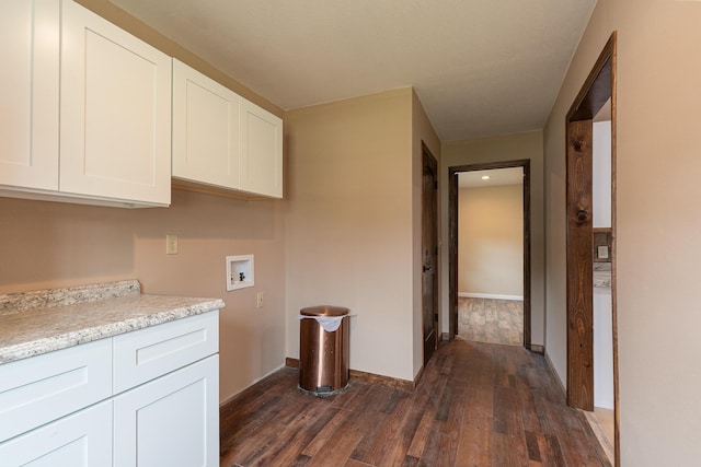 311 College St, Crane, MO 65633 - washroom with cabinet space, dark wood-style flooring, and washer hookup