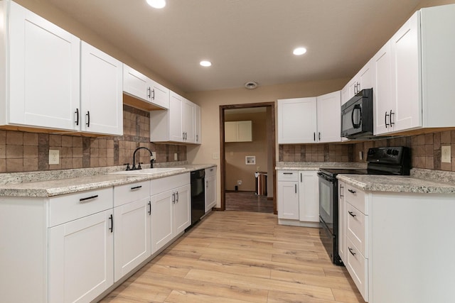 311 College St, Crane, MO 65633 - kitchen with black appliances, decorative backsplash, light wood finished floors, recessed lighting, and white cabinetry
