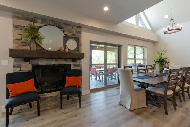 280 Lakefront Dr, Branson, MO 65616 - dining space with a stone fireplace, wood finished floors, plenty of natural light, a chandelier, and vaulted ceiling